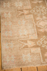 Textured low pile of a distressed Kars rug showing geometric starburst motifs in pale sand and terracotta.