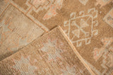 Corner of a distressed Kars rug folded to reveal the hand-knotted pile and woven foundation.