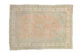 Vintage distressed Oushak rug with a pinwheel medallion in soft melon and seafoam green.