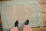 Evenly worn vintage Oushak rug with a faded palette of pale melon and soft seafoam green.