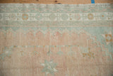 Detail of the vintage Oushak's floral gul border showing its even, hand-knotted pile.