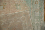 The reverse side of a vintage Oushak rug, showing the hand-knotted construction and secured edge.