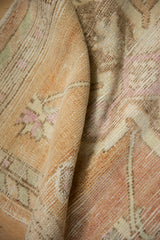 Textured pile of a vintage distressed Oushak rug in soft sandalwood and pale magenta hues.