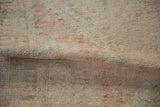 Distressed Oushak runner pile, with faded blush, ivory, and exposed foundation from wear.