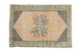 Distressed Oushak rug mat: ivory field, blue floral bouquets, checkered corners, vine border. 2'3
