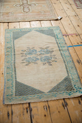 Distressed vintage Oushak rug with a checkered corner spandrel and meandering turquoise vine border.