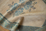 Textured hand-knotted Oushak rug pile with cream, sky blue floral motifs.