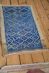 Distressed Oushak rug corner with blue lattice, heavy abrashes, natural camel border, and fringe.