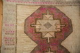 Evenly worn pile on a geometric medallion with fuchsia accents on a vintage Turkish rug.