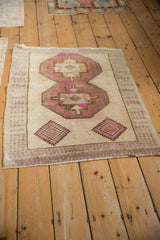 Angled view of a distressed vintage Kars rug showing its low pile and geometric design.