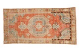 Distressed Oushak runner with a silver roundel medallion, brick red-orange field, and turquoise corner spandrels.