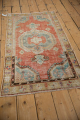 Angled view of a distressed Oushak runner's worn texture and brick red and turquoise pattern.