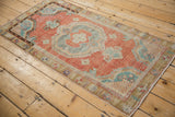 Angled perspective of a distressed Oushak runner with a roundel medallion and floral border.