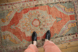 Overhead view showing the distressed texture and scale of a vintage Oushak rug in brick red.