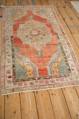 Angled perspective of a distressed Turkish Oushak rug, showing its colorful medallion and worn texture.