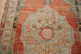 Close-up of distressed Oushak blossoms and vines with pops of bubblegum pink and saffron yellow.