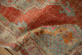 The soft, low pile of a distressed Oushak rug in brick red, slate blue, and bubblegum pink.