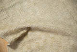 A folded corner of a vintage Tulu rug reveals its thick, shaggy pile and ivory tones.
