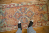 Distressed Oushak runner showing worn pile, diamond medallion, cantaloupe, faded blue, sea foam green.