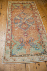 Distressed Oushak rug detail showing cantaloupe abrashed ground, faded blue spandrels, mostly even wear.