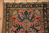 Corner of the vintage Mehreban mat showing its serpent border and worn, low pile.