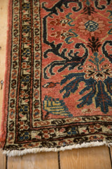 Corner view of a vintage Mehreban rug's serpent border and evenly worn pile.