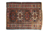Antique Caucasian rug, geometric medallions, starburst field, brick red, sapphire blue, ivory.