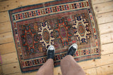 Antique Caucasian rug corner with geometric patterns in brick red, sapphire, and fuchsia.