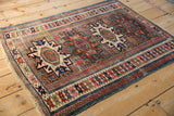 Worn geometric border and fringe detail of an antique Caucasian rug, in sapphire, fuchsia, and brick red.