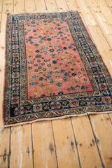 Vintage Persian Lilihan rug corner featuring navy double vine pinwheel border and fringe.