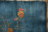 Art Deco rug corner, sky blue field with dusty rose blossom, intact side selvage.