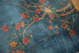 Vivid sky blue field of the Art Deco rug with sprawling dusty blush blossoms.