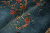 Sprawling branches of dusty rose blossoms on a plush denim blue Art Deco rug pile.