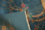 Close-up of hand-knotted foundation, blue field, and tattered fringe of Art Deco rug.