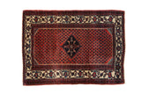 Vintage Engelas rug with a navy diamond medallion, allover red boteh pattern, and a wide ivory border.