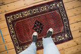 Showing the real-life scale of a small vintage Engelas rug with a brick-red boteh field.