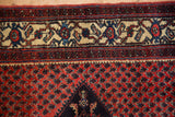 The ivory main border with blue Turtle Samovar motifs beside the brick-red boteh field.