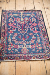 Perspective view of an antique Kerman rug with a tree of life design and dragon-style border.
