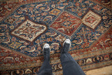 Standing view of a fine antique Qashqai rug's Herati pattern in sapphire blue and chestnut.