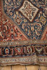 Angled close-up of the low, even wear and intricate border motifs on an antique hand-knotted Qashqai rug.