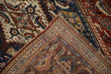 Folded corner of an antique Qashqai rug showing the intricate border and hand-knotted back.