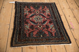 Vintage Persian Bibikabad rug corner detail, dusty red field, blue floral, and boteh border.