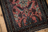 Bibikabad rug detail: faded cochineal field, blue floral vines, serrated leaves, and boteh border.