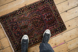 Angled perspective showing the unidirectional floral pattern of a vintage Sarouk rug.