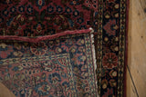Corner of a fine Sarouk rug revealing the hand-knotted foundation, dense pile, and side selvage.