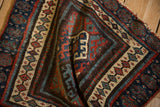 Corner of an antique Jaff Kurd rug showing ivory seed motifs and madder red, sapphire blue floral borders.
