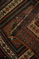 Antique Persian Jaff Kurd rug detail: hook-and-latch guls, sapphire, madder red, visible tatter.