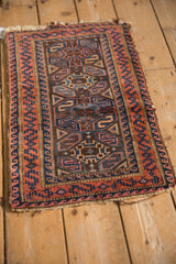 Belouch rug close-up: cobalt, madder serpent and wave borders with tattered edge.