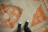 Distressed Kars carpet: stepped terracotta contours, sage green, and starburst motifs.