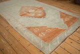 Distressed vintage Kars carpet corner with terracotta spandrel and starburst floral motifs.